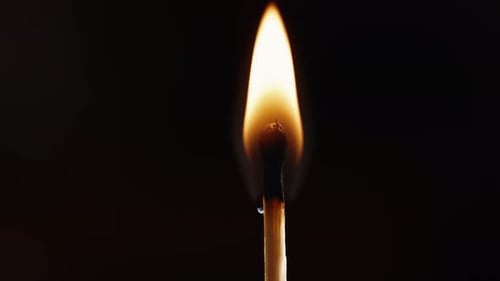 Burning Matchstick Against Dark Background