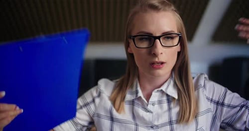 Overheated Young Adult Woman Fanning Herself in Office