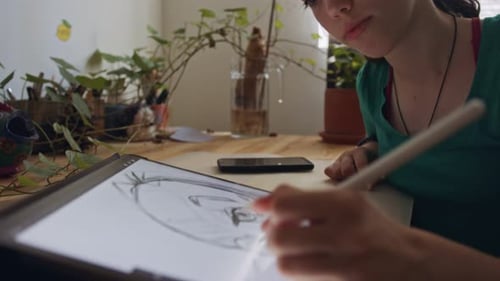 Teenage girl drawing using a tablet computer and an electronic pen