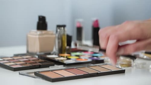 Makeup Artist Using Brush on Colorful Eye Shadow Palette