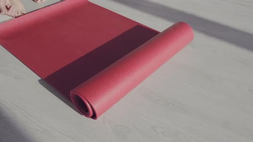 Woman Unrolls Yoga Mat for Home Fitness