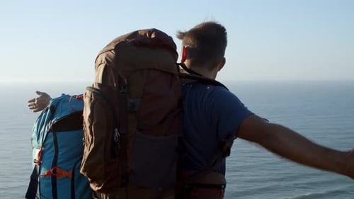 Couple of Excited Tourists with Backpacks Standing at Cliff