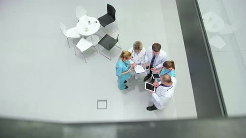 Medical Team Discussing Information in Hospital Lobby