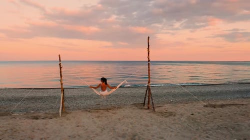 Girl on the Swing in front of the Ocean