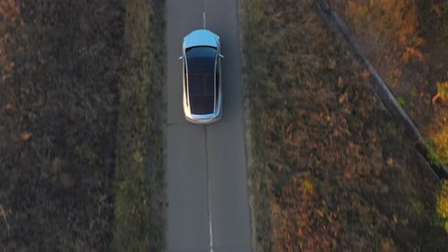 Aerial Shot of Electrical Car Driving Through Country Road at Summer Evening. Modern Vehicle Passing