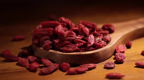 Goji Berries Poured into Wooden Bowl Close Up
