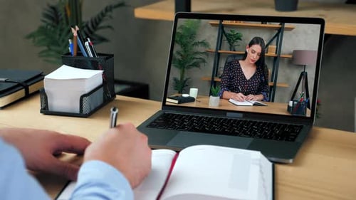 Person Watching Online Lecture and Taking Notes