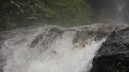 Waterfall Cascading Over Rocks in a Tropical Forest