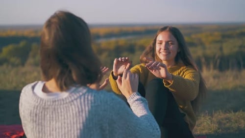 Happy Women Hikers Do Abs Exercises on Hilly River Bank