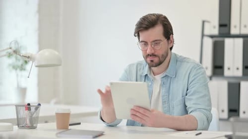 Adult Using Tablet Computer at Bright Office Desk
