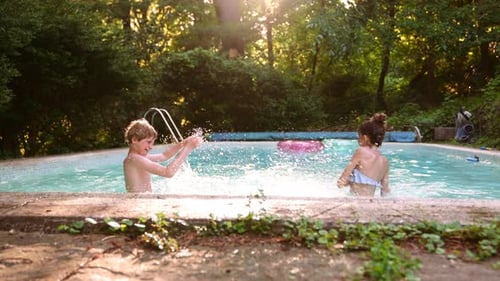 Two Kids Boy and Girl Having Fun in the Pool
