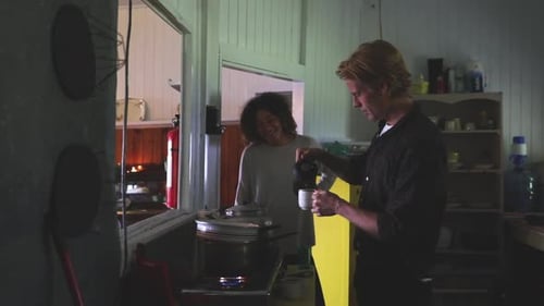 Adults Smile at Home While Pouring Drink