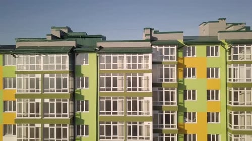 Aerial footage of a tall residential apartment building with many windows and balconies
