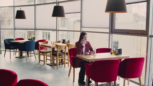 Young Woman Talking on Phone in Restaurant