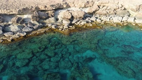 Aerial Top View Footage By Drone of Ocean Blue Water and Rocks A Calm Sea Washes the Rocky Mountain