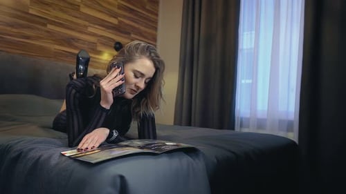 Young Woman Talking on Phone on Bed