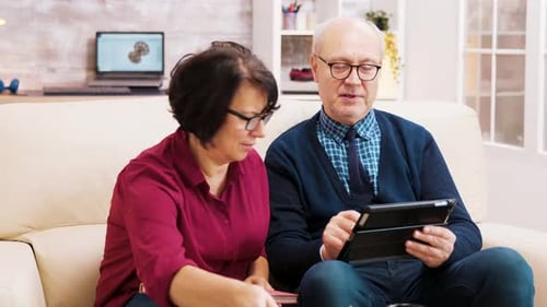 Senior Couple Using Tablet Together on Sofa