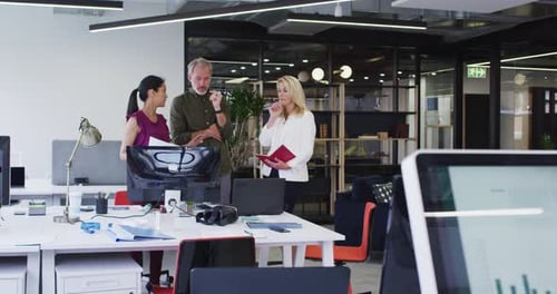 Diverse Geschäftskollegen stehen am Computer und diskutieren im Büro