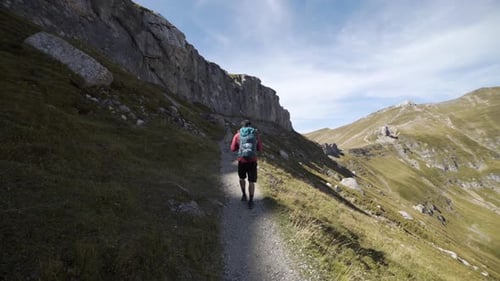 Person with Backpack Hiking in High Altitude Mountain Environment During Autumn