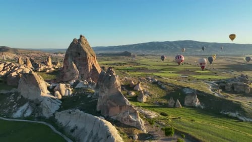 4K Aerial view of Goreme. Colorful hot air balloons fly over the valleys.
