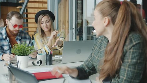 Diverse Business Team Working in Office Using Laptop Sharing Documents Enjoying Cooperation
