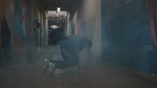 Breakdancer Performs Energetic Moves in Urban Hallway