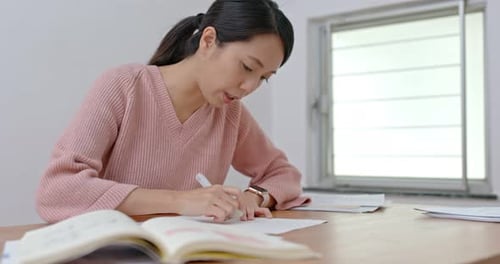 Woman Studying and Writing at Desk Indoors