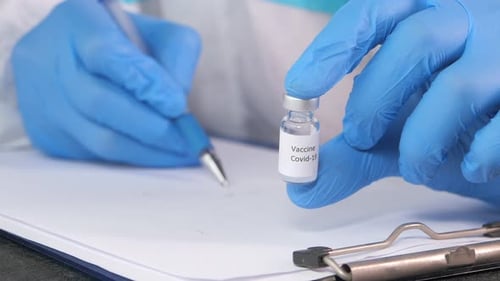 Doctor Hand in Gloves Holding Coronavirus Vaccine, Close Up
