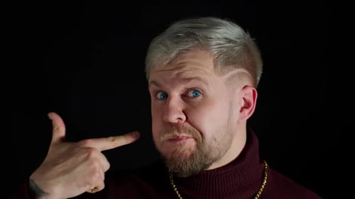 Man Makes Finger Gun Gesture with Playful Expression