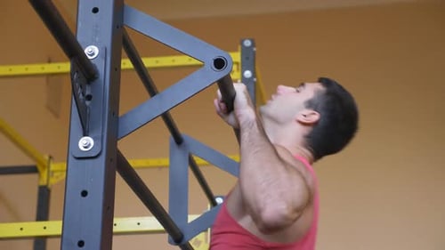 Strong Sporty Man Doing Pull Ups at Gym