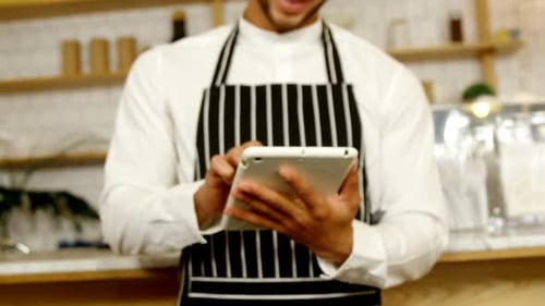 Smiling waiter using digital tablet 4 4k