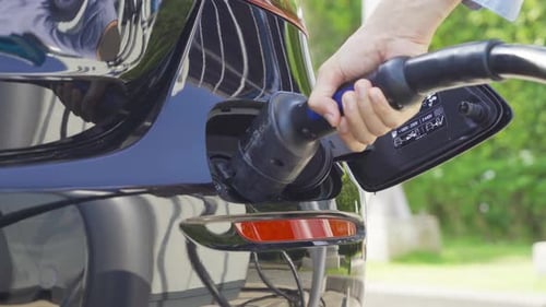 Einstecken von Hand in das Autoladegerät für Elektrofahrzeuge oder Elektrofahrzeuge. Kabelanschluss zur Tankstelle, Stromversorgung