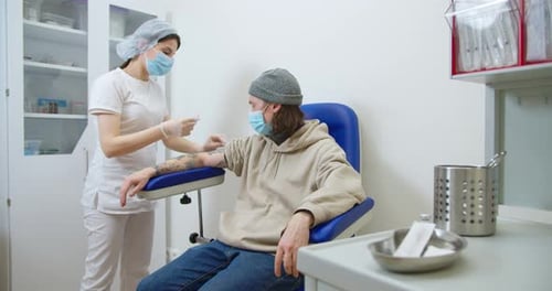 Healthcare Worker Prepares Injection for Young Adult Patient