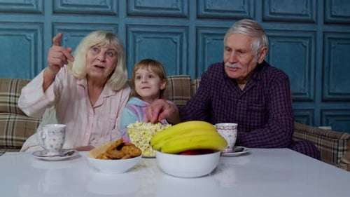 Grandparents and Child Watching TV Together