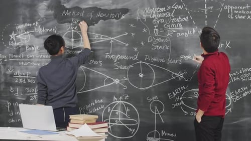 Two Scientists Working at Chalkboard in Lab