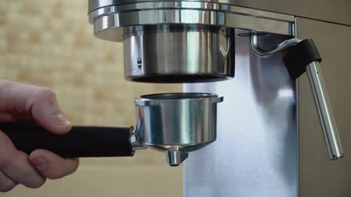 Hand Inserts Portafilter into Coffee Machine