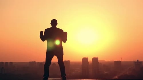 Man Celebrating Success at Sunrise