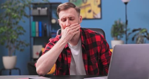 A Tired and Bored Teenage Student Boy Yawns and Falls Asleep Sitting in a Chair