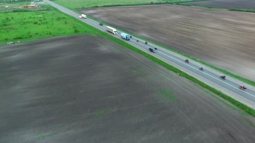 Aerial shot of collumn of motobikers driving road on spring afternoon