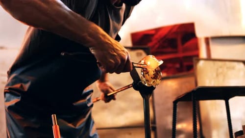 Glassblower Shaping Molten Glass with Tools