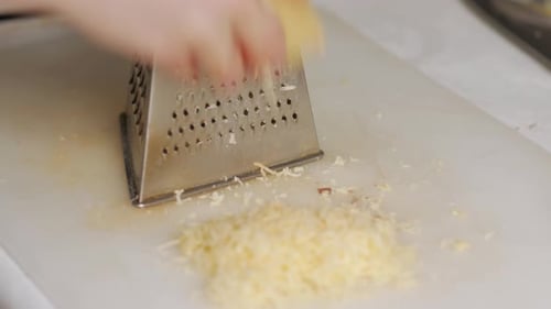 Cheese Being Grated with a Metal Grater