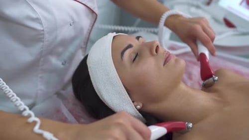 Cosmetologist Giving Facial Massage to Lying Woman