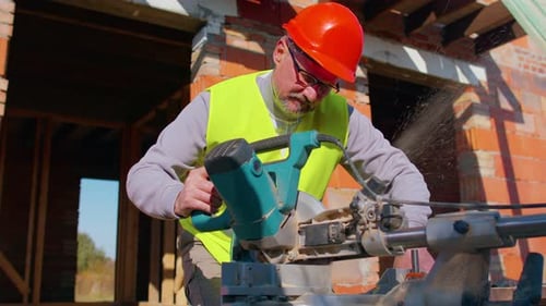 Construction Worker Using Chop Saw on Building Site