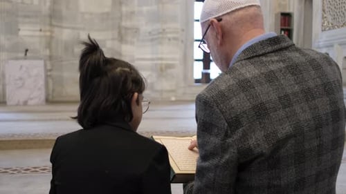 Man and Child Study Religious Book in Mosque