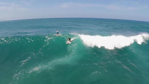Aerial view of a man sup stand-up paddleboard surfing in Hawaii.