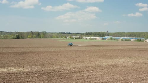 Farm Tractor in Field. Ecological Farming Concept of a Soil Plowing