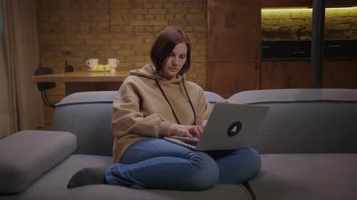 Woman Working on Laptop While Sitting on Couch