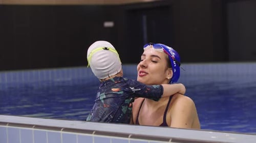 Young Woman Instructor with a Little Kid in the Swimming Pool