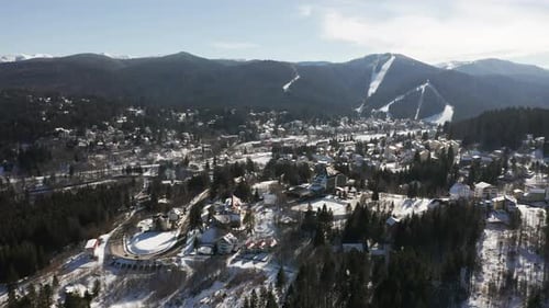 Vue aérienne de la ville de Predeal, Roumanie ; montagnes de Clabucet au loin.