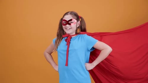 Girl Posing as Superhero with Cape and Mask